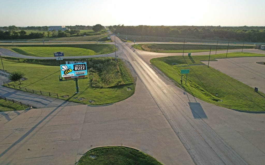 A road with signs and grass on the side.