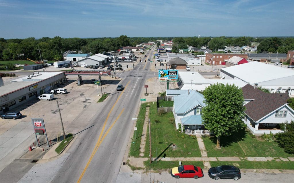 An aerial view of a street with cars parked on the side.
