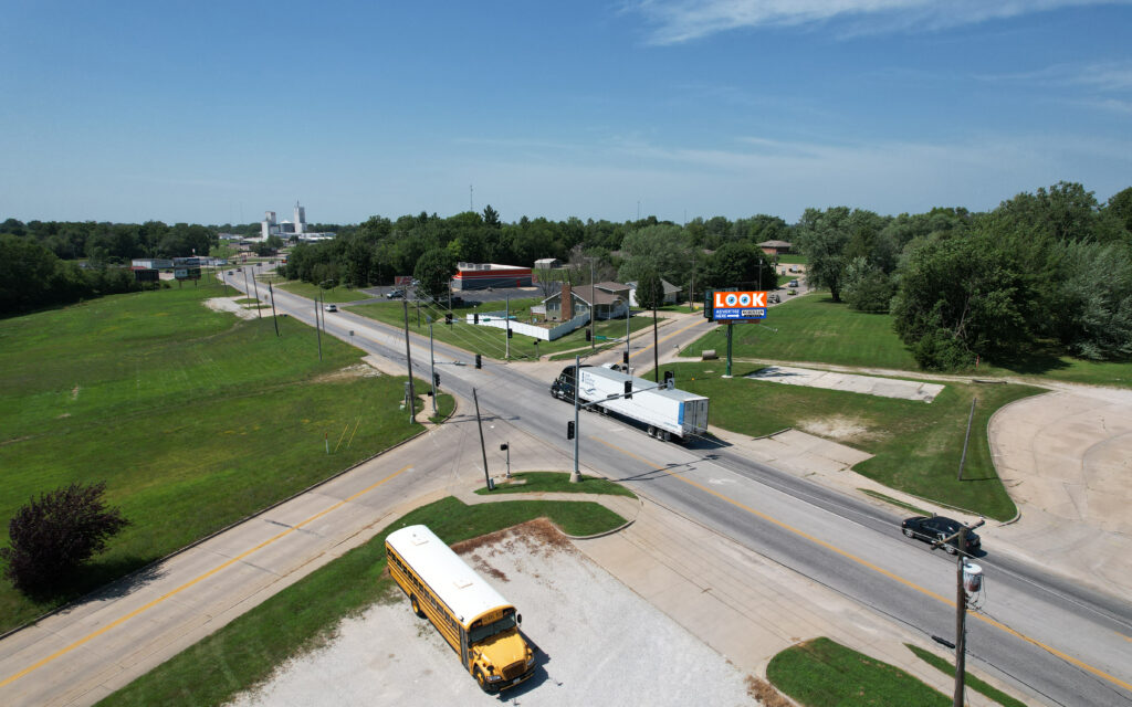 A school bus driving down the road near a street sign.