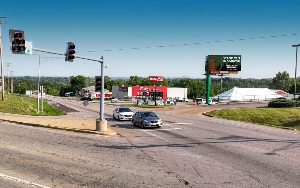 A street with cars driving on it and a traffic light.