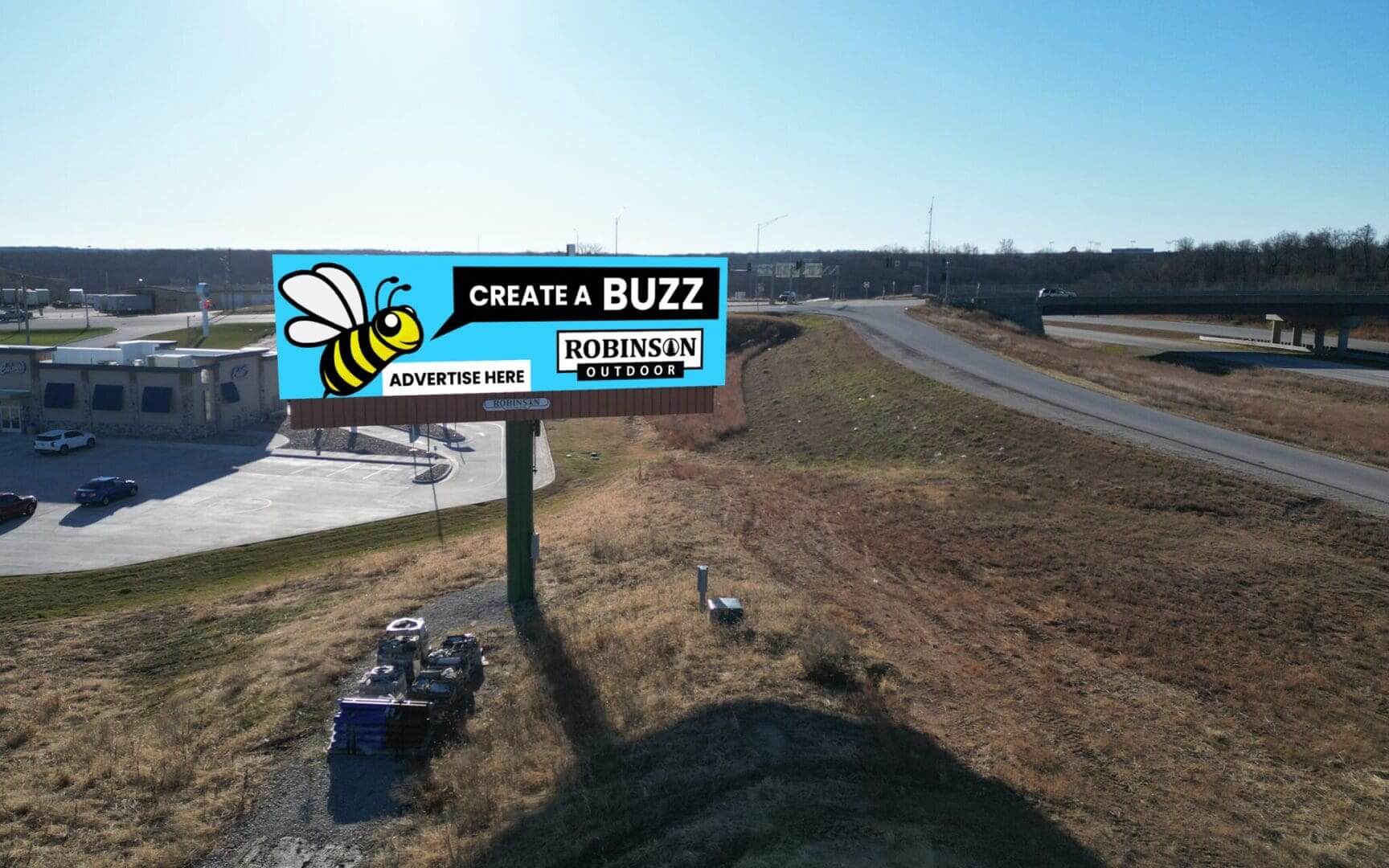 A billboard with a bee on it is sitting in the middle of nowhere.