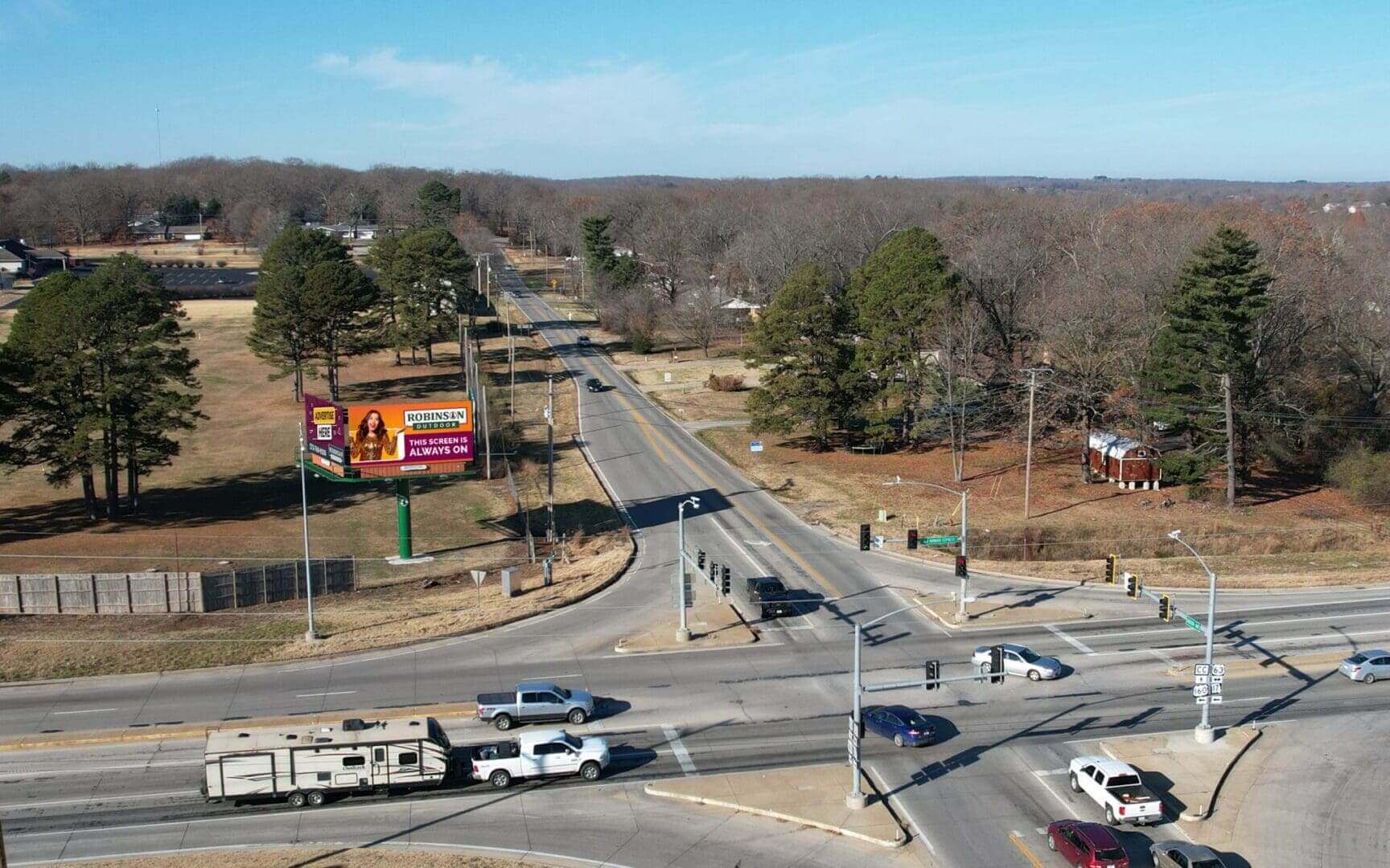 A view of an intersection with cars driving on it.