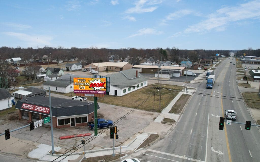 A view of an intersection with cars driving down the road.