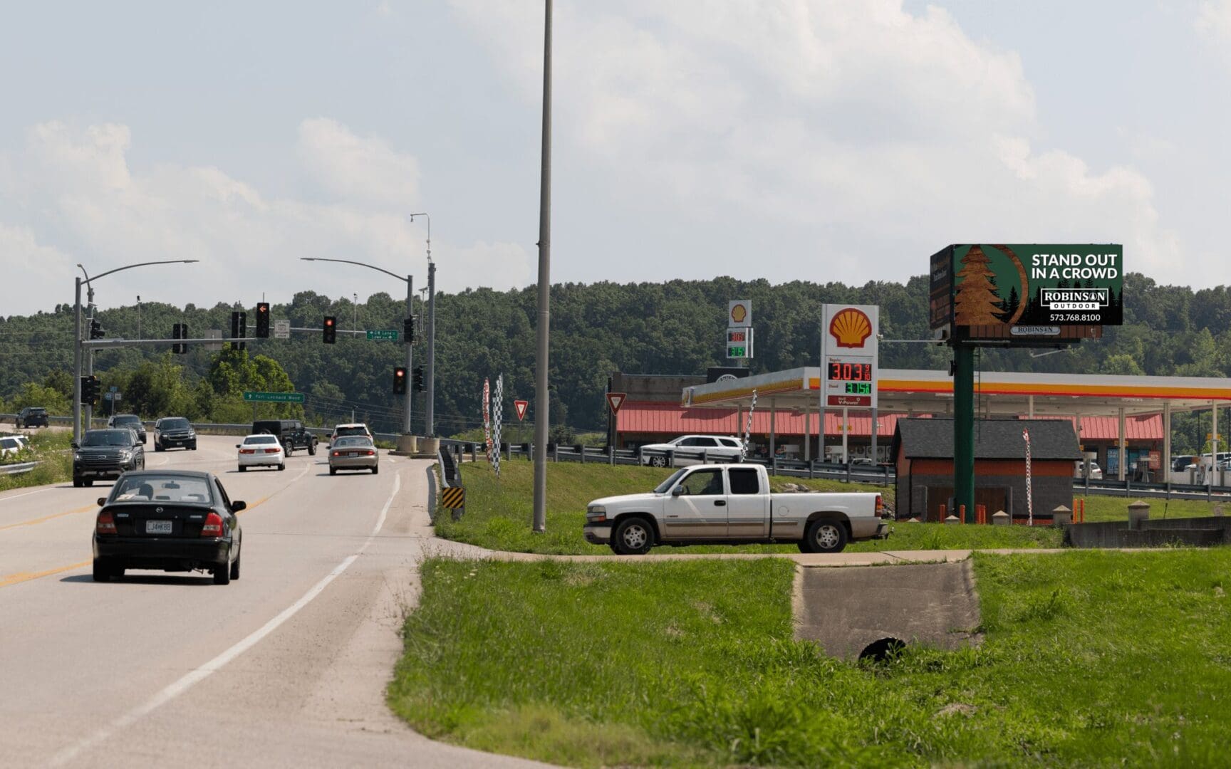 A truck is driving down the road near gas stations.