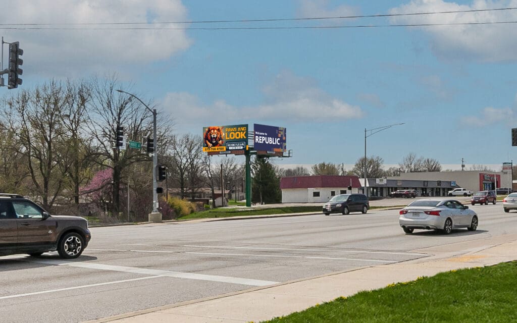 A car driving down the street next to a road sign.