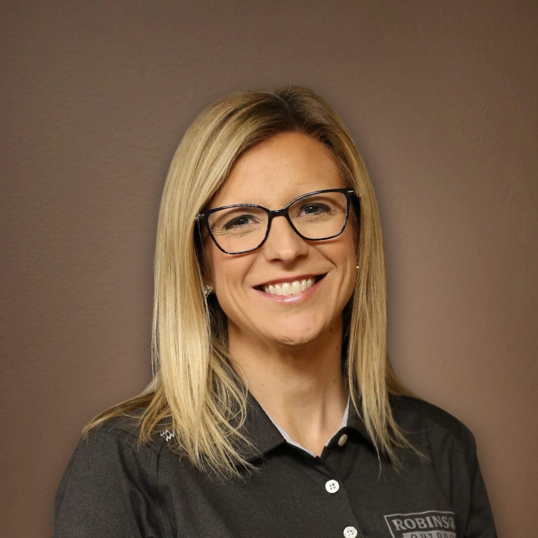 A woman with glasses is smiling for the camera.