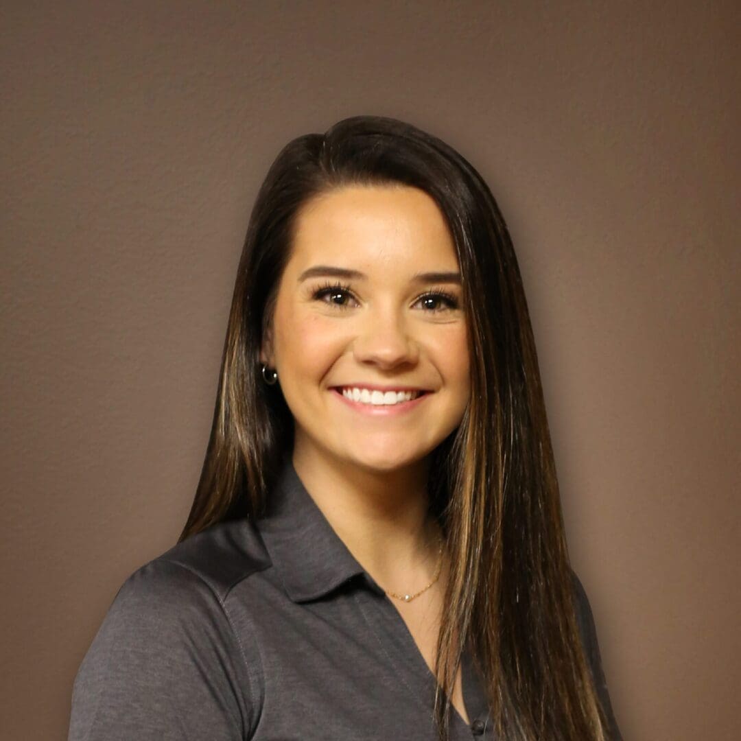 A woman with long hair and a gray shirt.