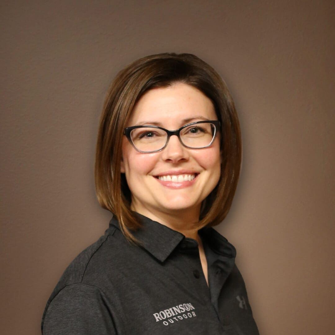 A woman wearing glasses and smiling for the camera.