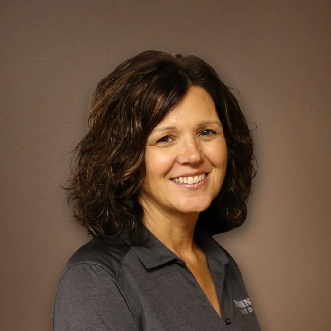 A woman with brown hair and a gray shirt.
