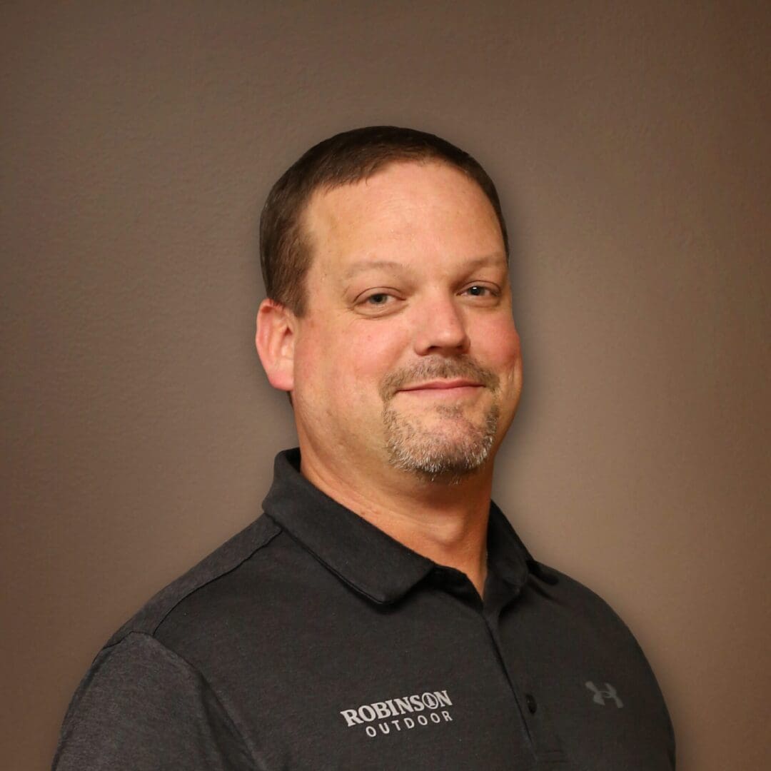 A man in black shirt standing next to wall.