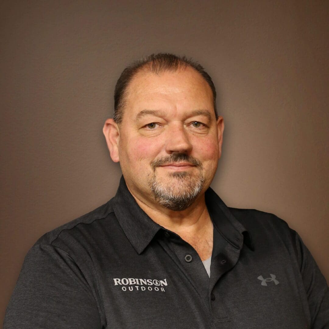 A man with a beard and mustache wearing black shirt.