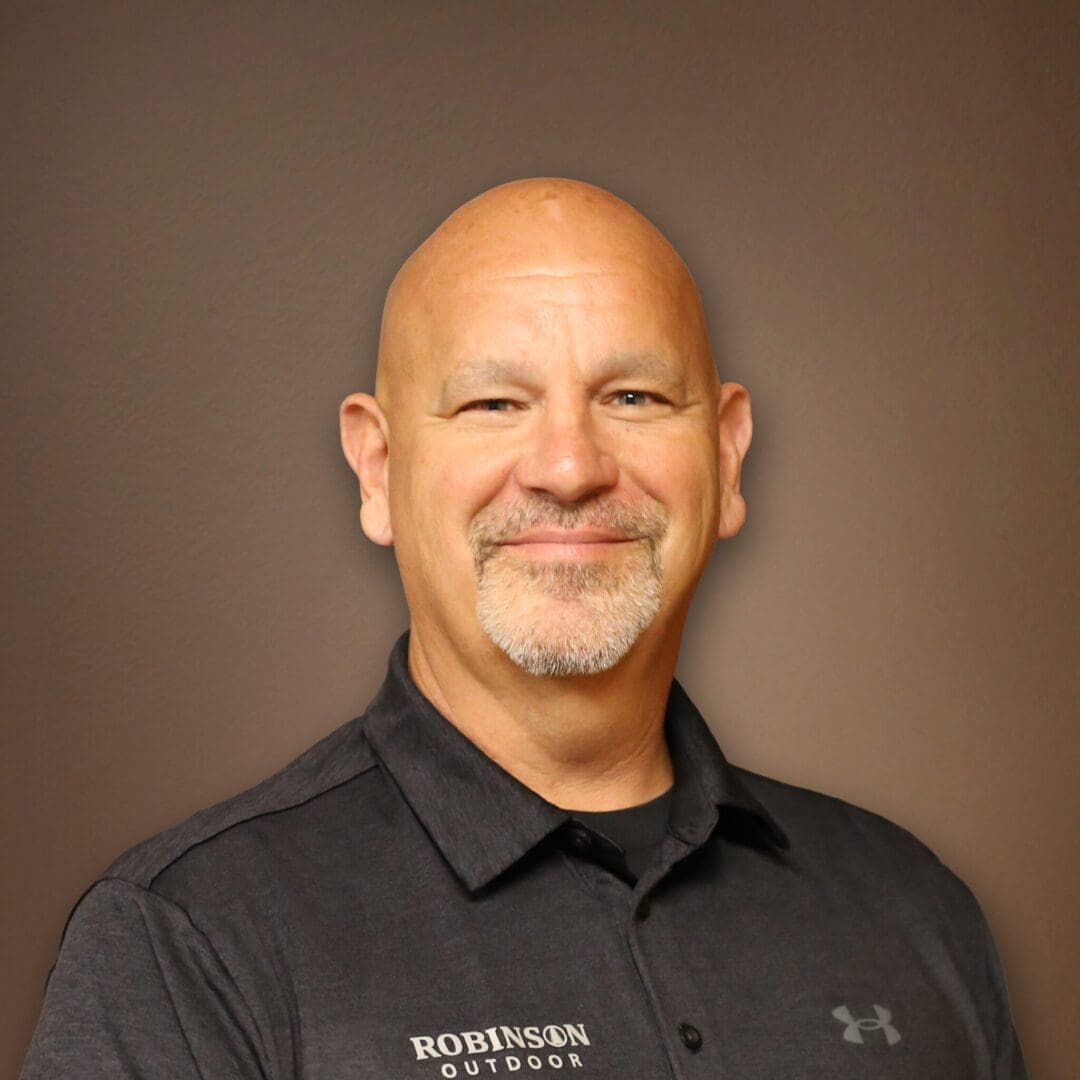 A man with bald head and mustache wearing black shirt.