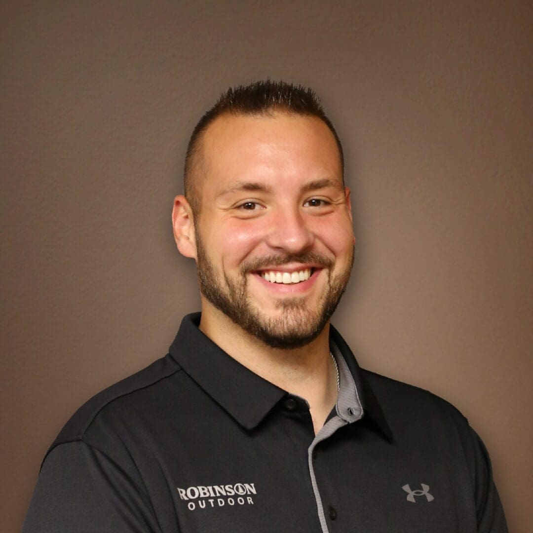 A man in black shirt smiling for the camera.