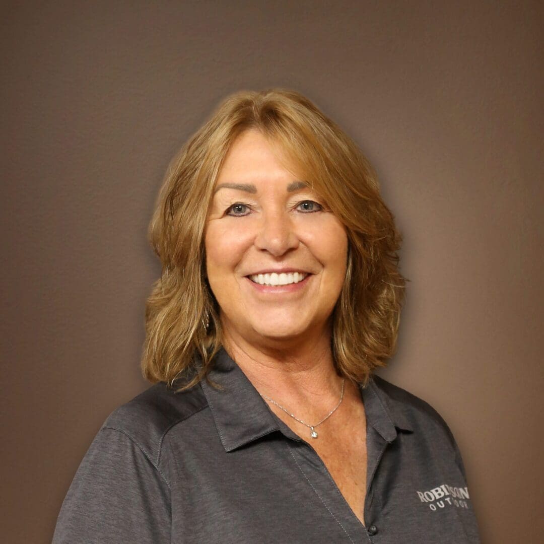 A woman with long hair wearing a gray shirt.