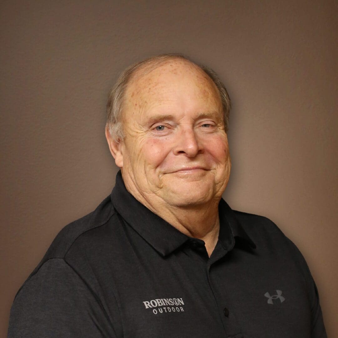 A man in black shirt smiling for the camera.