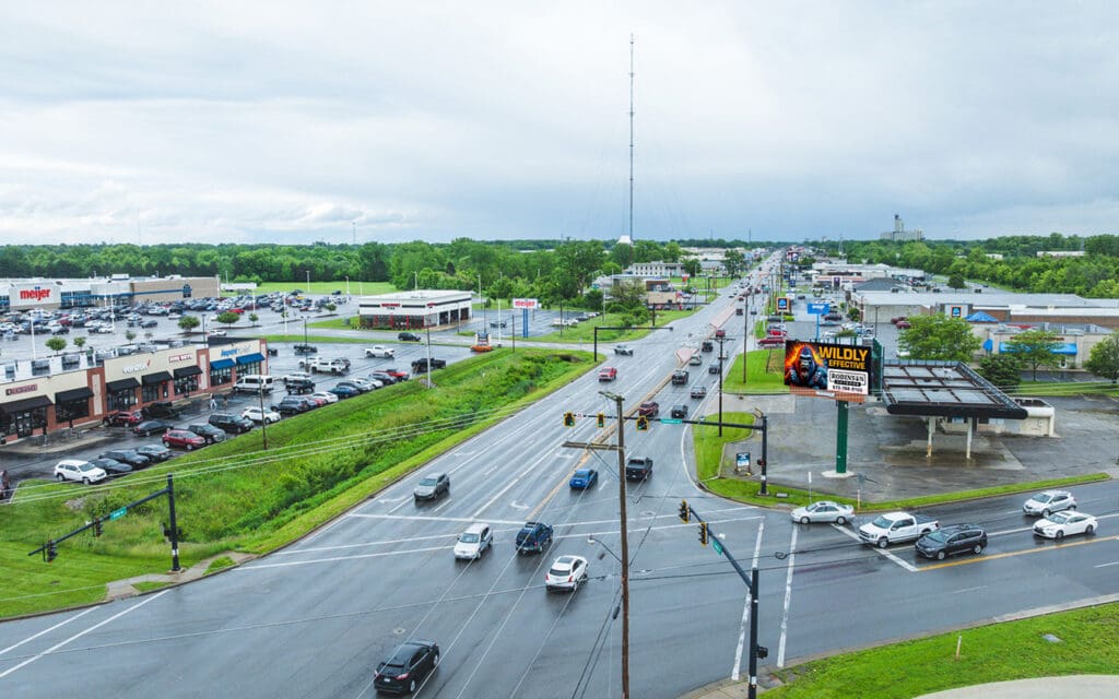Busy highway with cars and green landscape on a cloudy day.