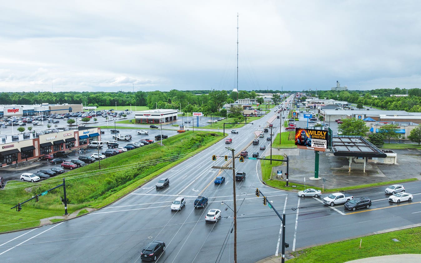 Busy highway with cars and green landscape on a cloudy day.