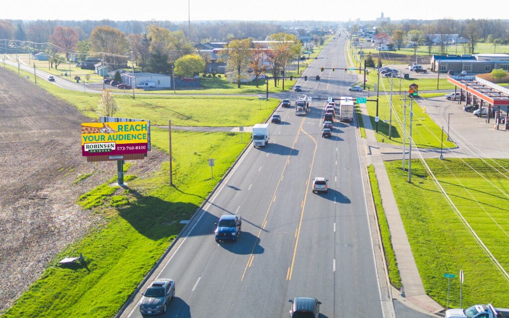 A busy multi-lane road with cars during daytime in a suburban area.