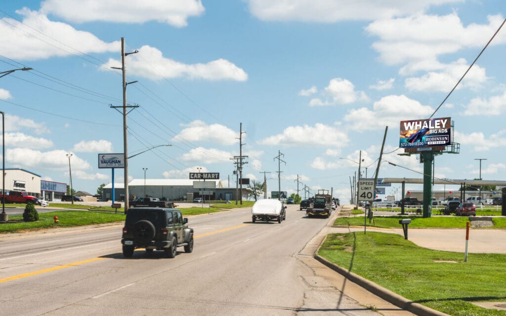 Suburban highway with cars, billboard, car dealership