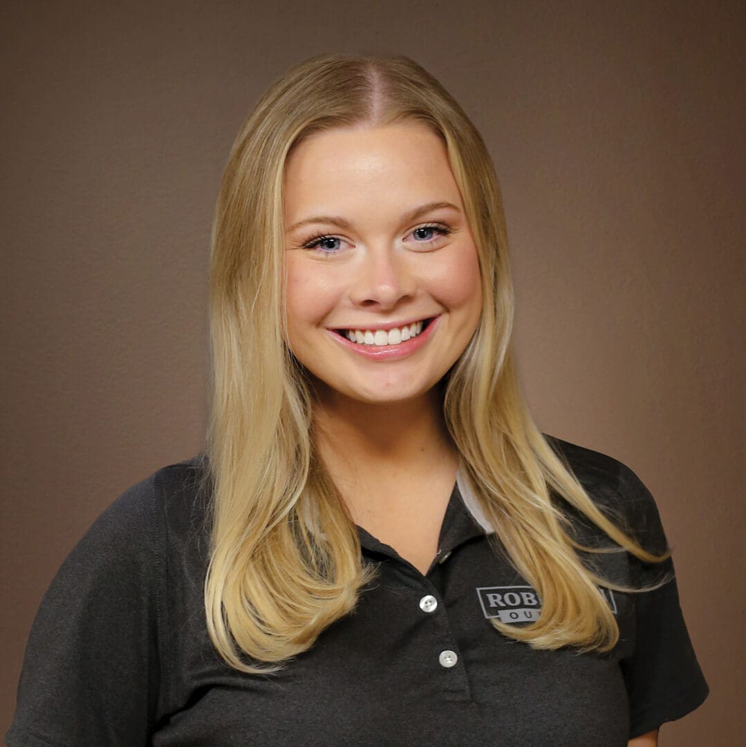 Smiling young blonde woman wearing dark polo