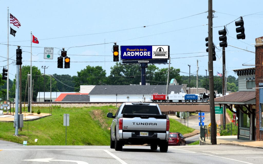 Pickup truck at small town intersection under billboard