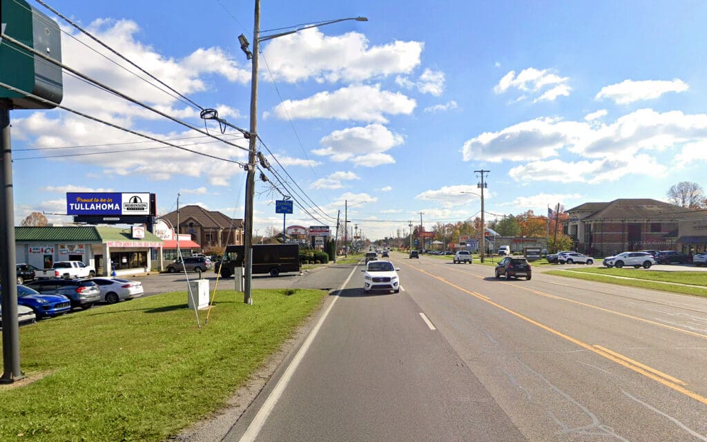 Suburban roadway with cars and storefronts