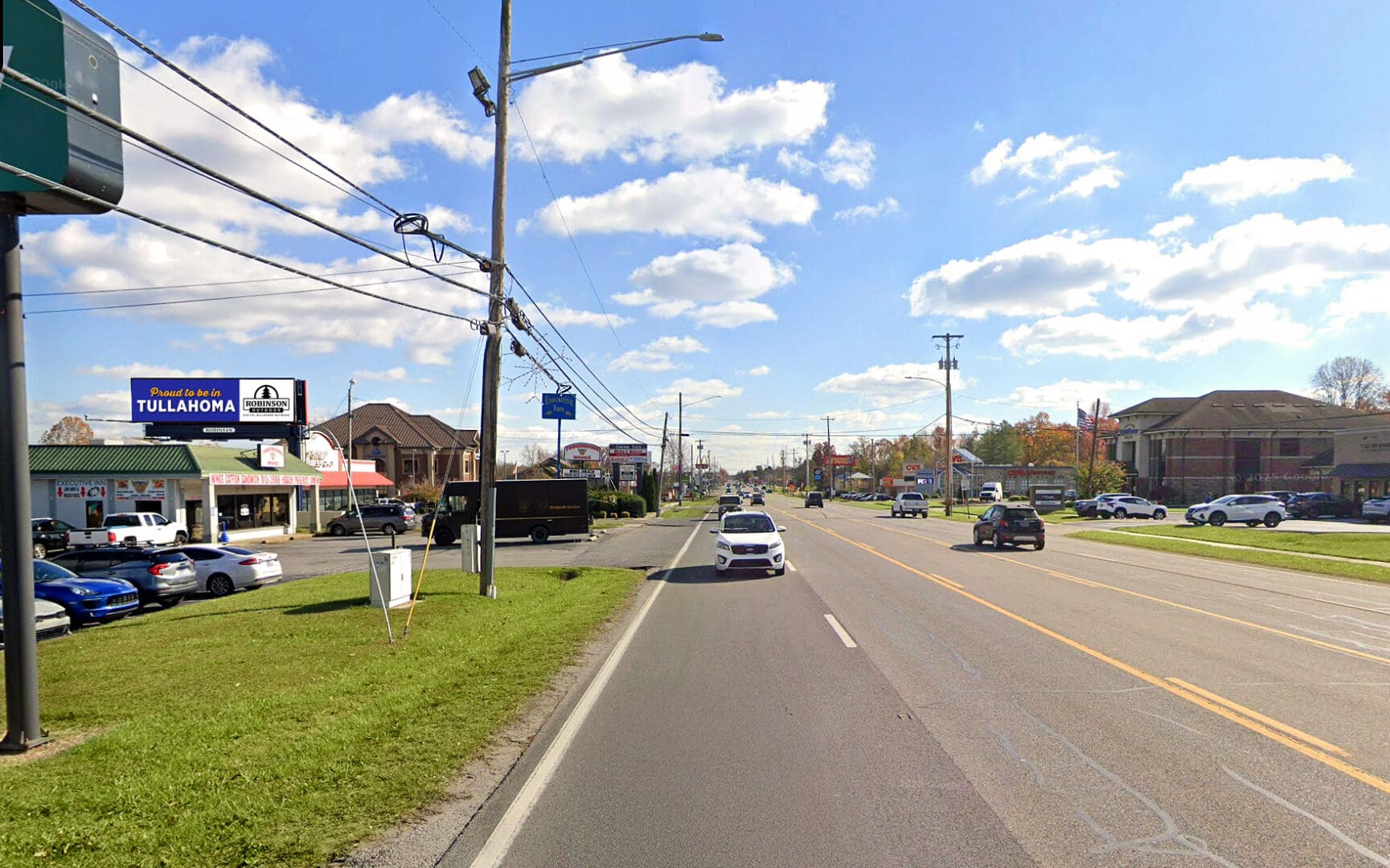 Suburban roadway with cars and storefronts