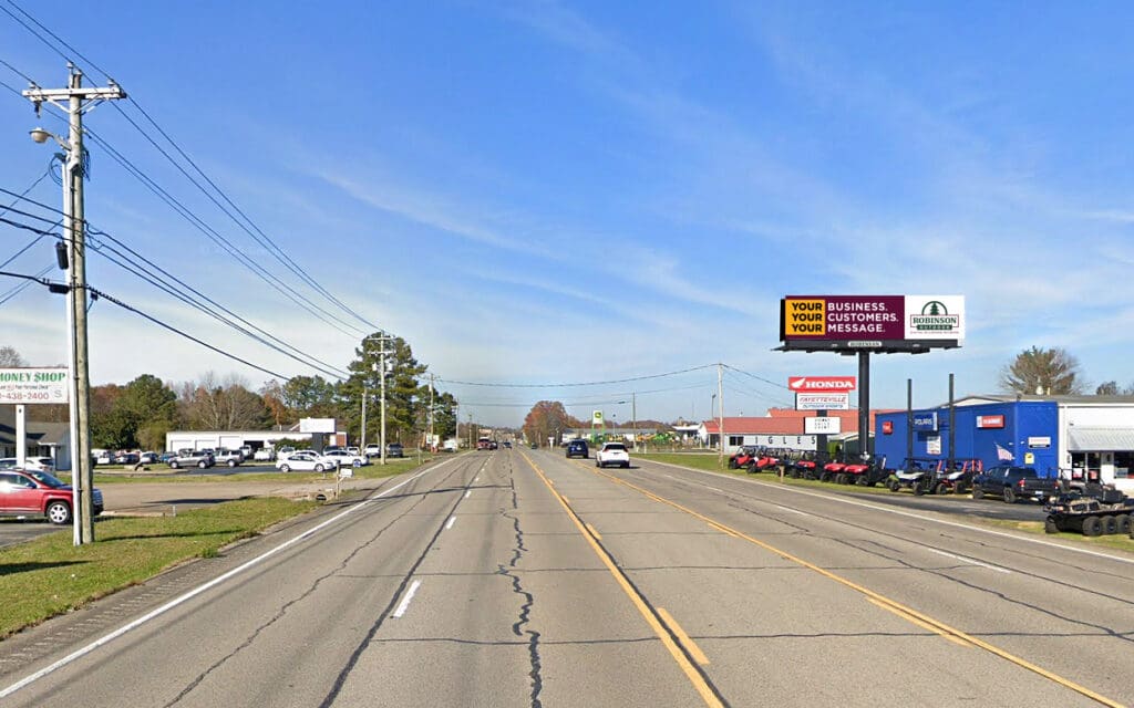 Wide suburban road with billboards and cars