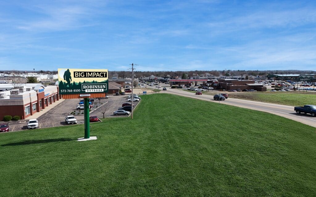 Billboard on grassy berm near highway
