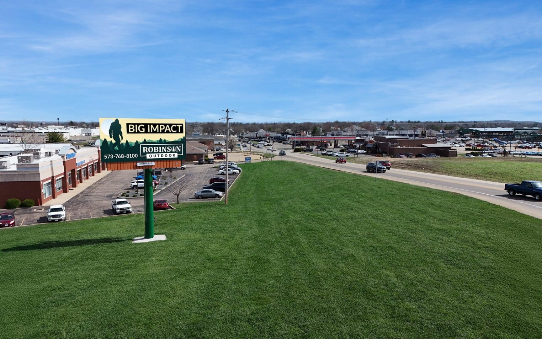 Billboard on grassy berm near highway