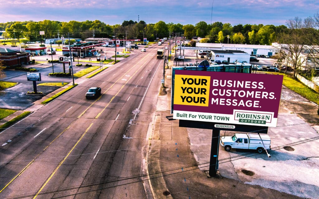 Large roadside billboard beside suburban street